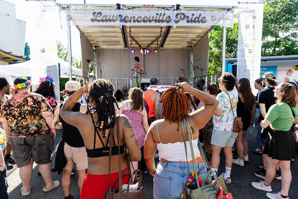 People celebrating Pride in front of a stage