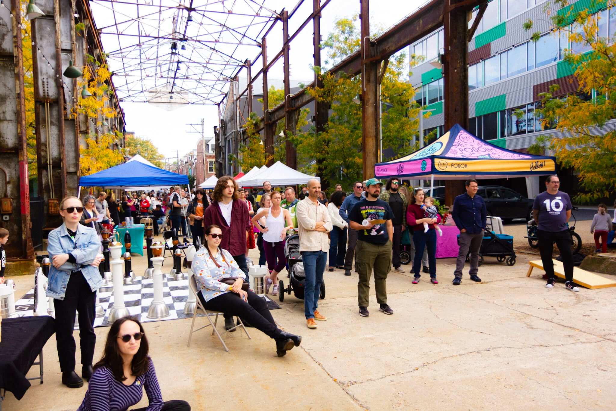 A large crowd gathers for a performance at a the outdoor market.
